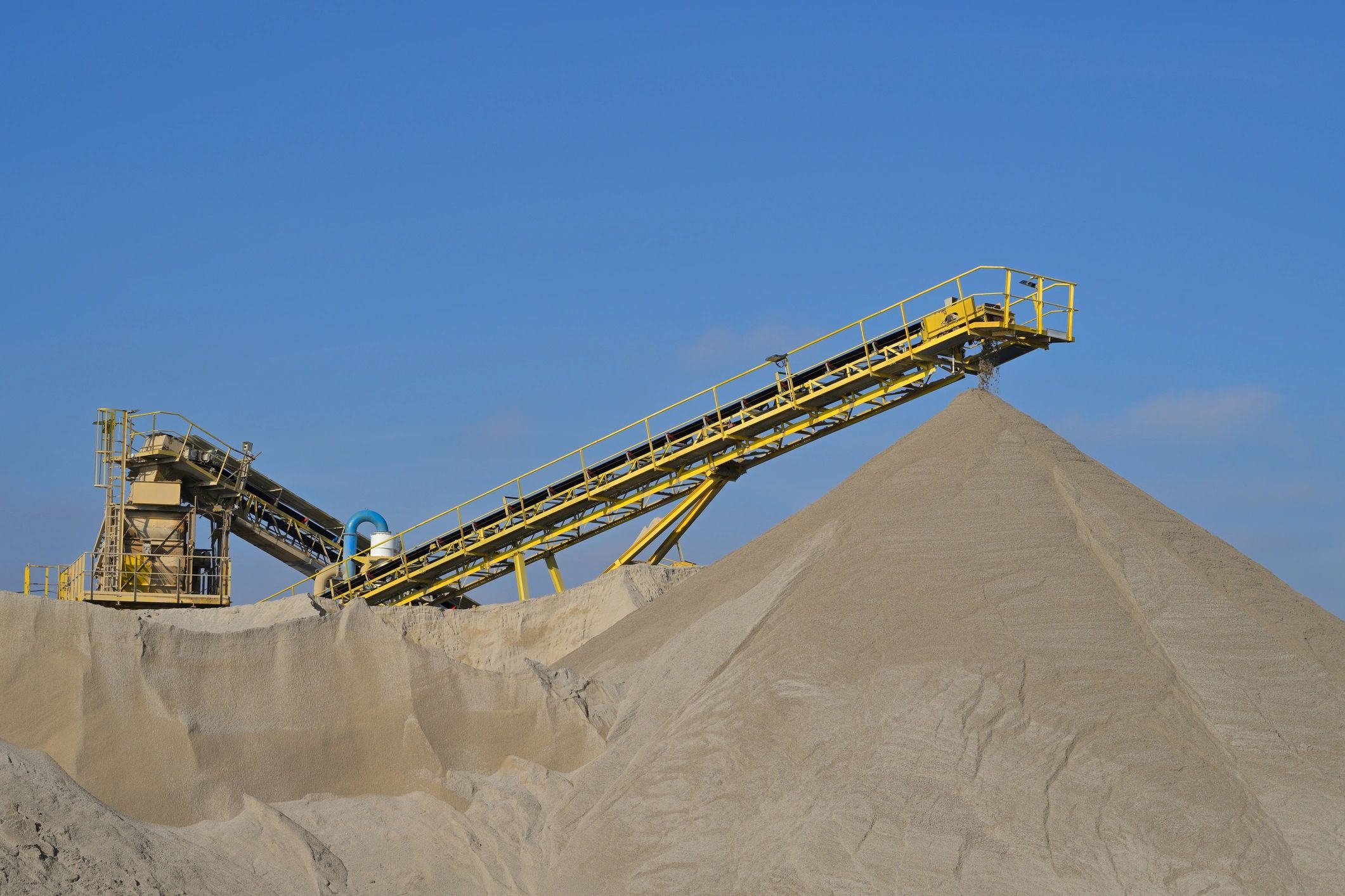 Conveyor industrial moviendo material a granel en sitio de extracción, vista lateral
